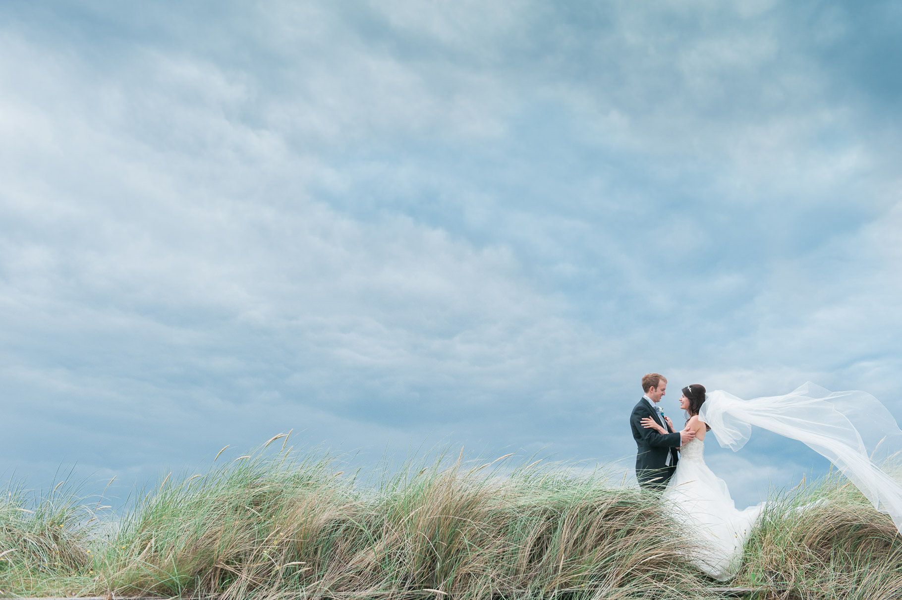 Bride and Groom on Scottish beach in Troon on a windy day