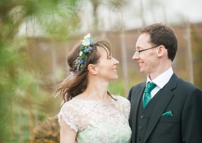 Bride wearing green dress in Bellahouston Park in Glasgow with groom at House For An Art Lover Wedding