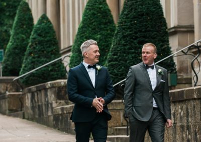 Groom and Best Man walking along the victorian terrace of One Devonshire Gardens in Glasgow